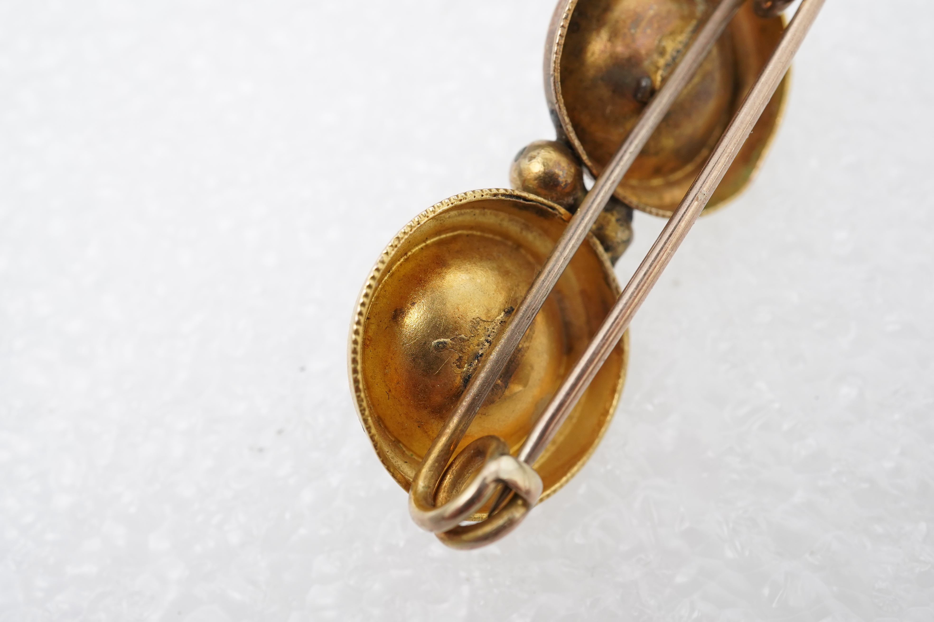 A Victorian ruby and gold double target brooch, late 19th century and later, composed of two roundels set with circular-cut garnets, with wirework details, length 3.7cm, gross weight approximately 3.5 grams